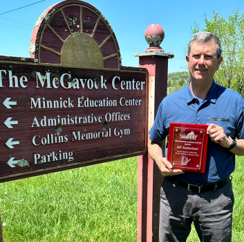 Bill Sutherland poses with his award next to the Minnick sign