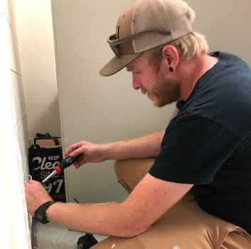 Logan uses a screw driver to replace an outlet cover