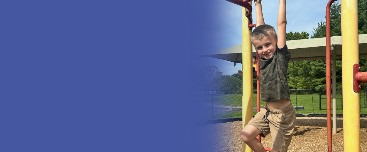 A student hangs from monkey bars