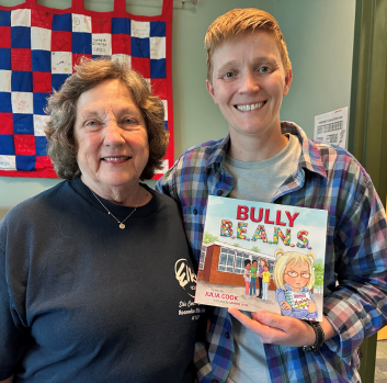 Barbara and Becca smile while Becca holds a book called Bully Beans