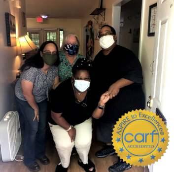 Four people pose for a photo in a foyer of a home