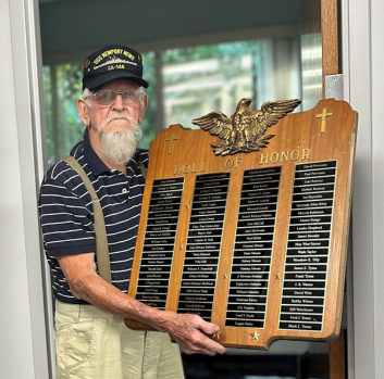 Noah holds a Role of Honor plaque