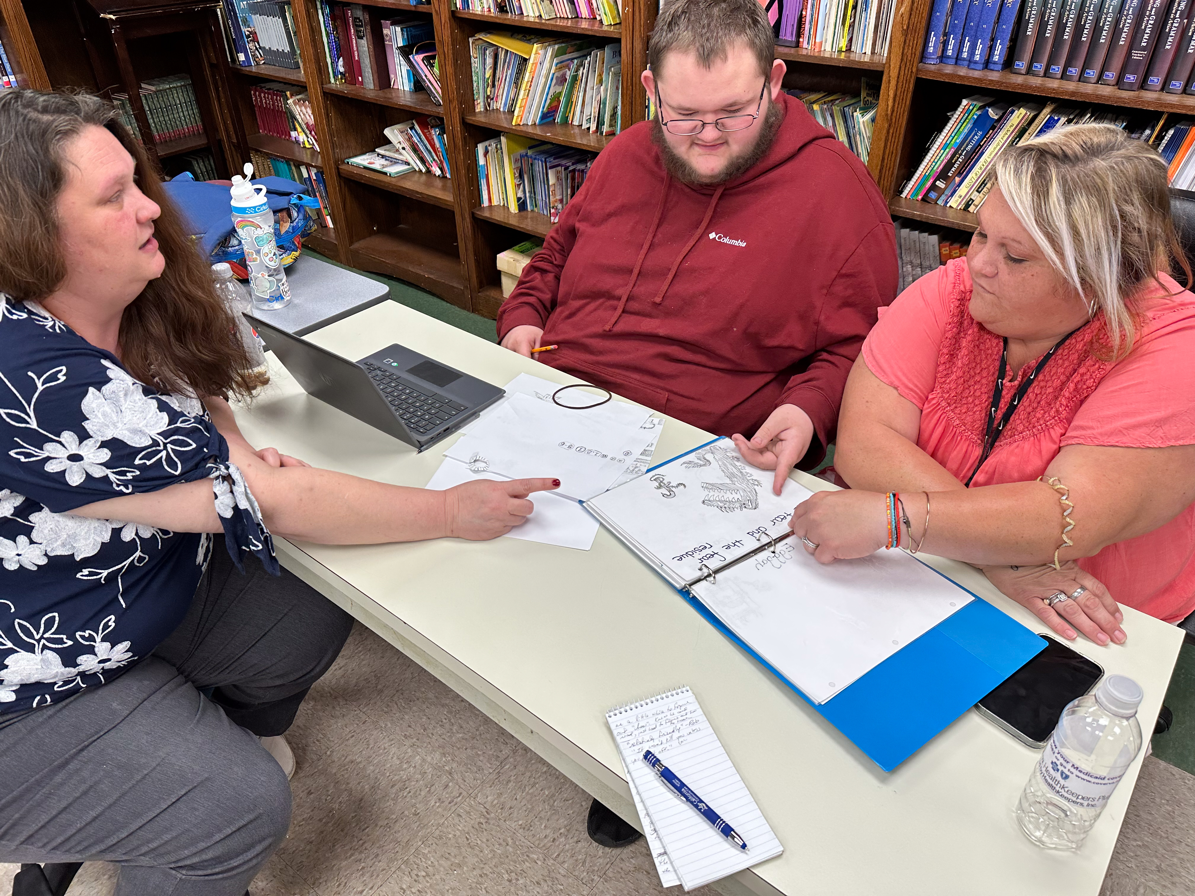 Robert Woody shares his drawings with his teachers