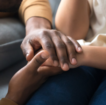 Two black hands hold a Latino hand