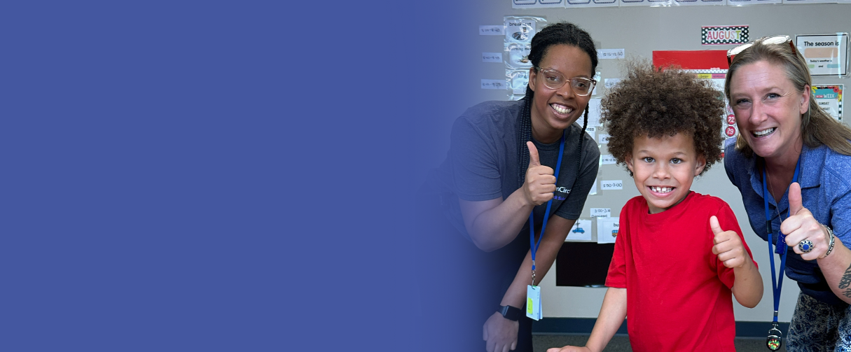 Two teachers and a student give a 'thumbs up' to the camera