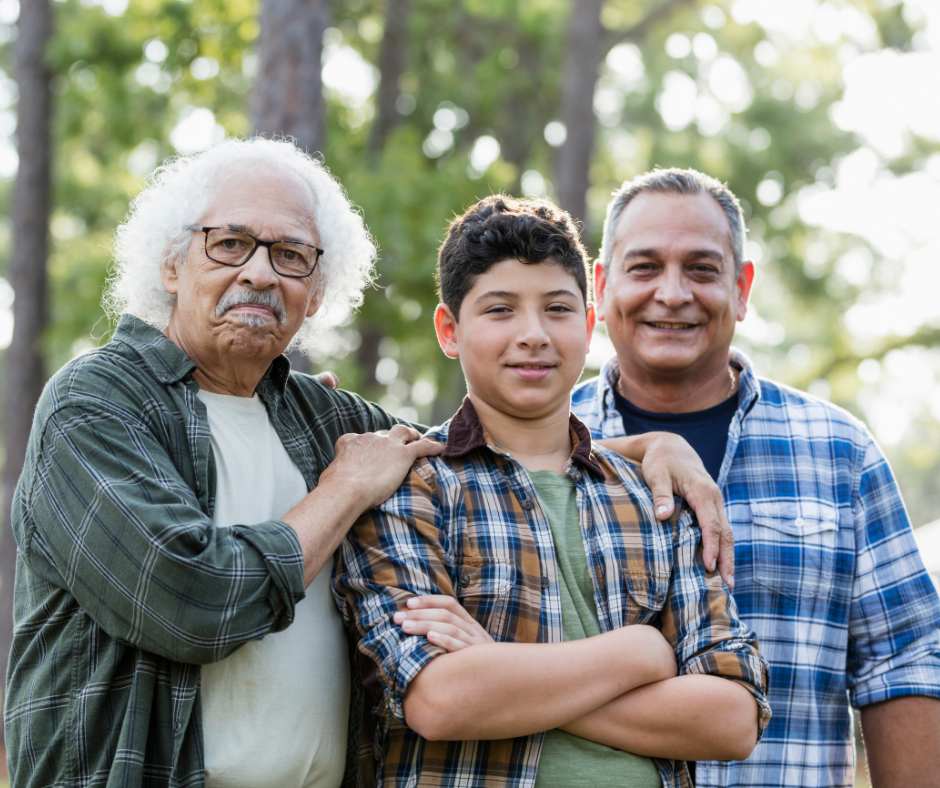 Three generations of Latino men smile at the camera