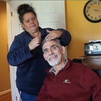 A woman combs a smiling man's hair