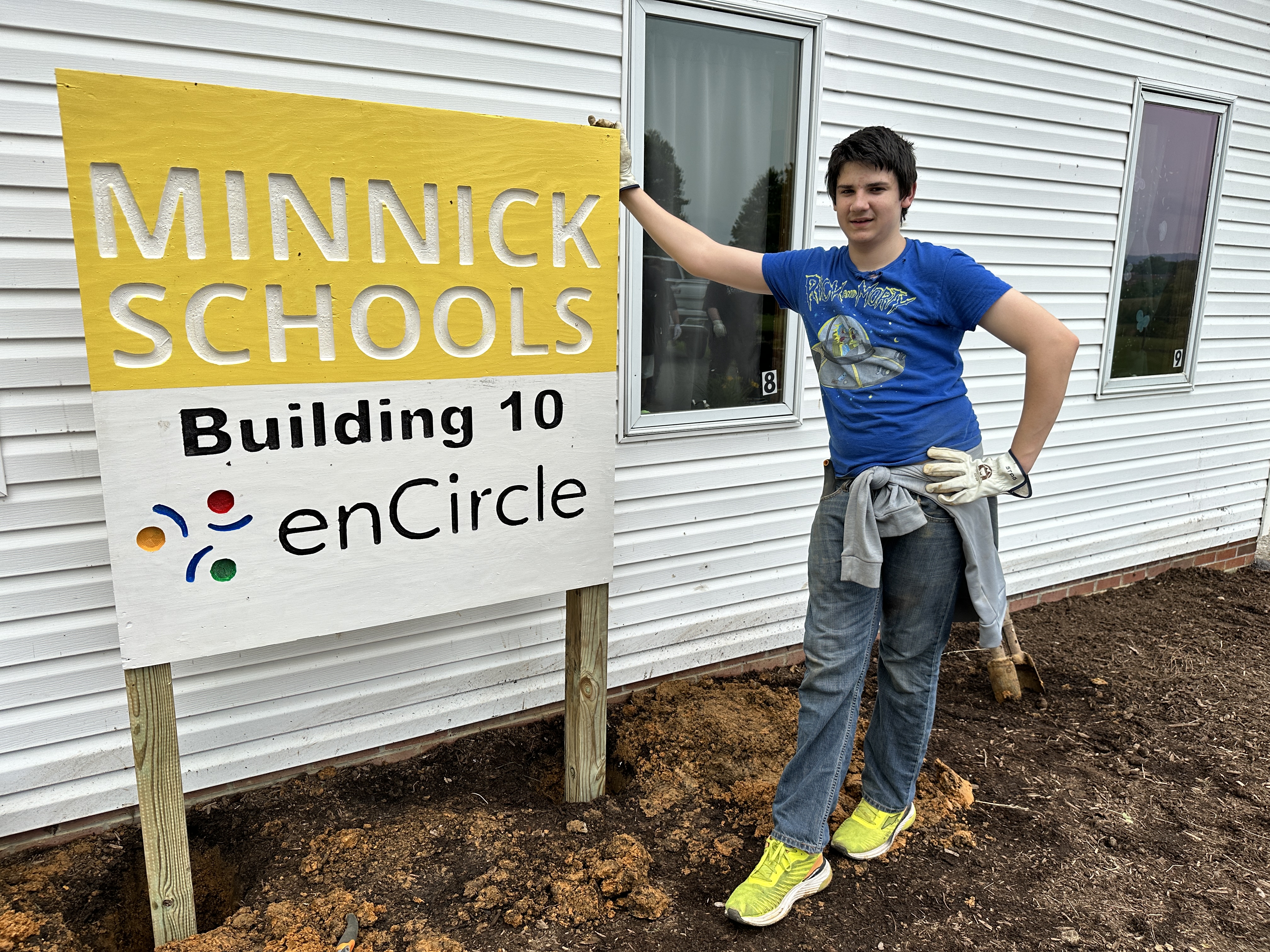 A student poses with a Minnick Schools Building 10 sign