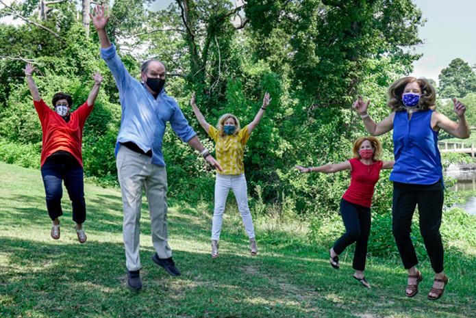 enCircle leadership team jumping in the air in an outdoor setting
